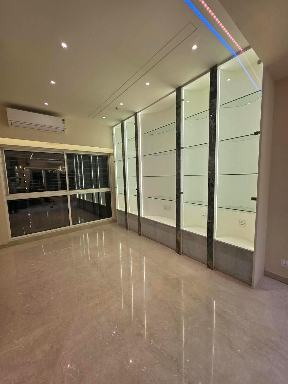 Backlit glass display shelves framed by stone-clad pillars