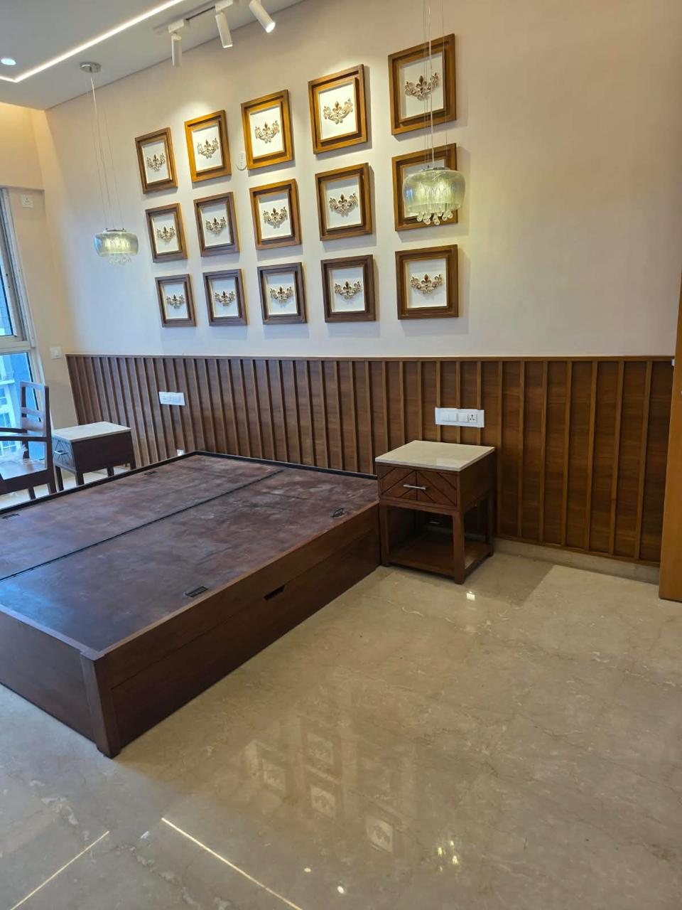 Bedroom with framed wall art, fluted wooden wainscoting and walnut storage bed
