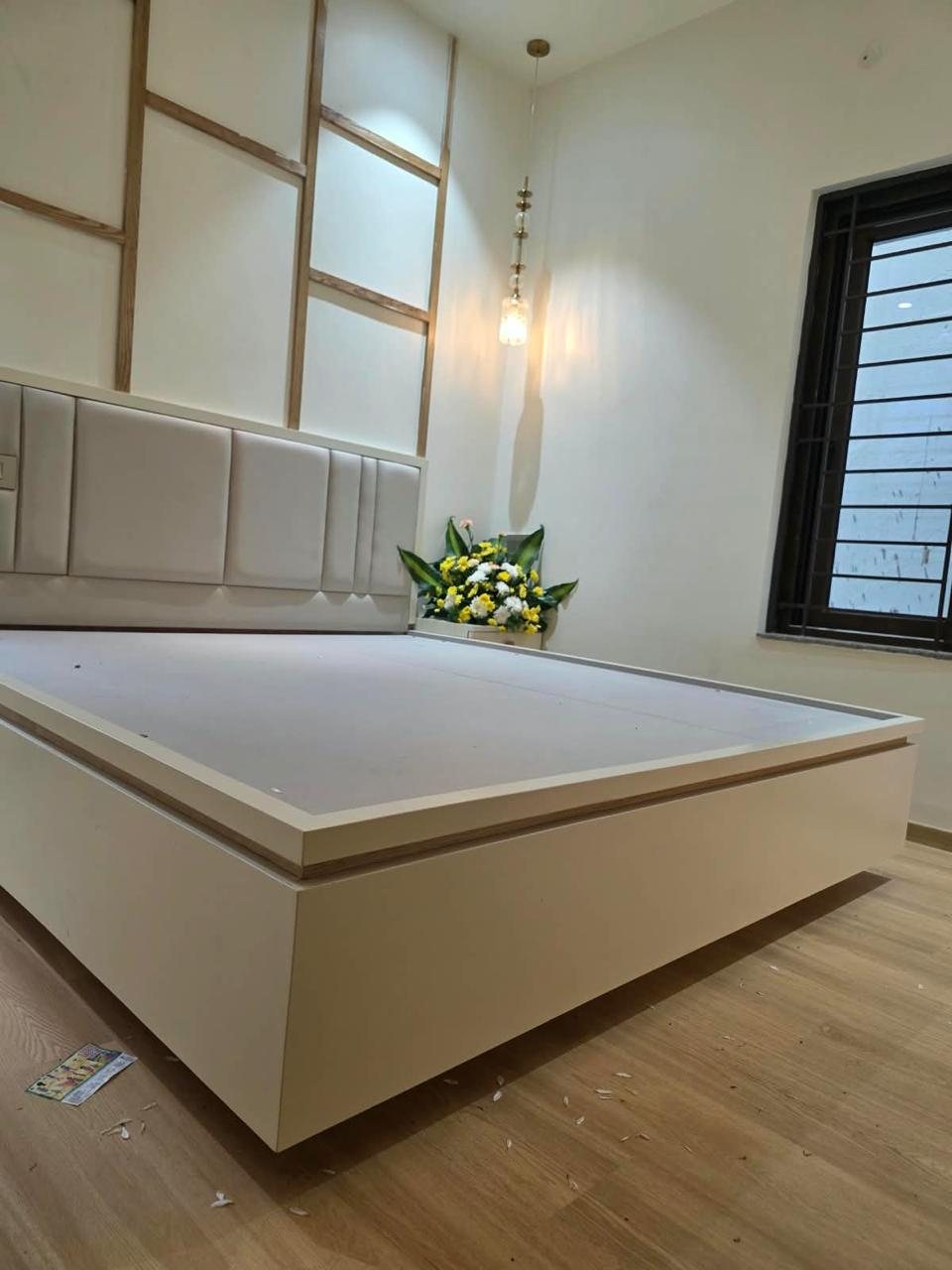Bedroom with oak-trim wall panels, upholstered headboard and crystal pendant