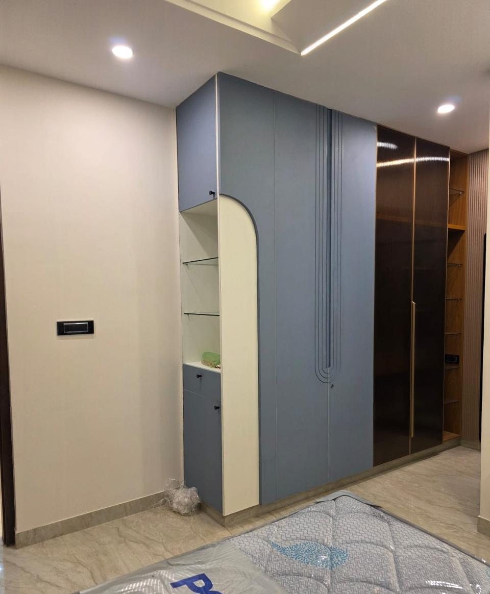 Powder-blue wardrobe with arched open shelf and grooved door detail