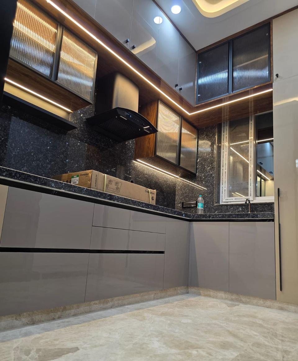 Grey modular kitchen with granite backsplash, fluted-glass cabinets and LED strips