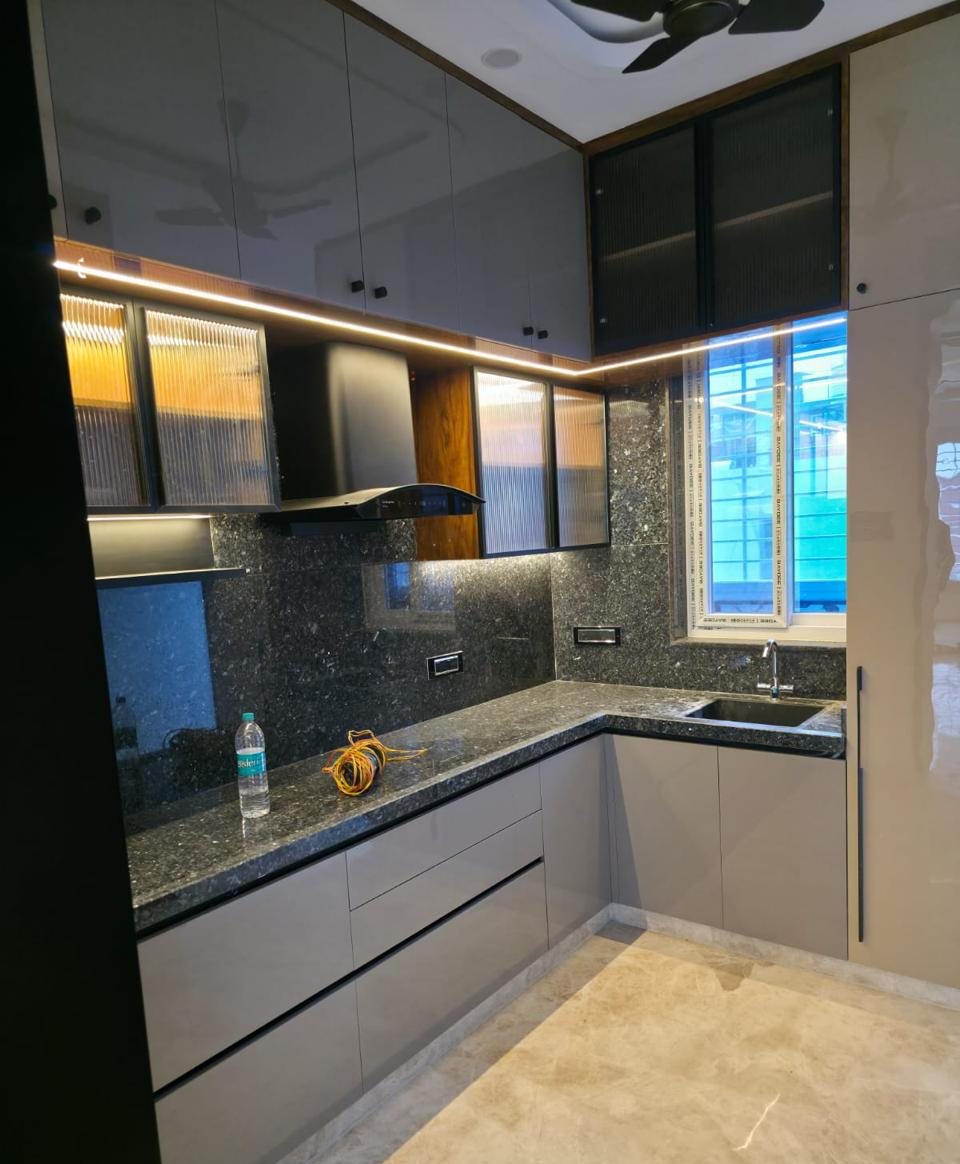 Grey L-shaped kitchen with granite counter and fluted-glass wall cabinets