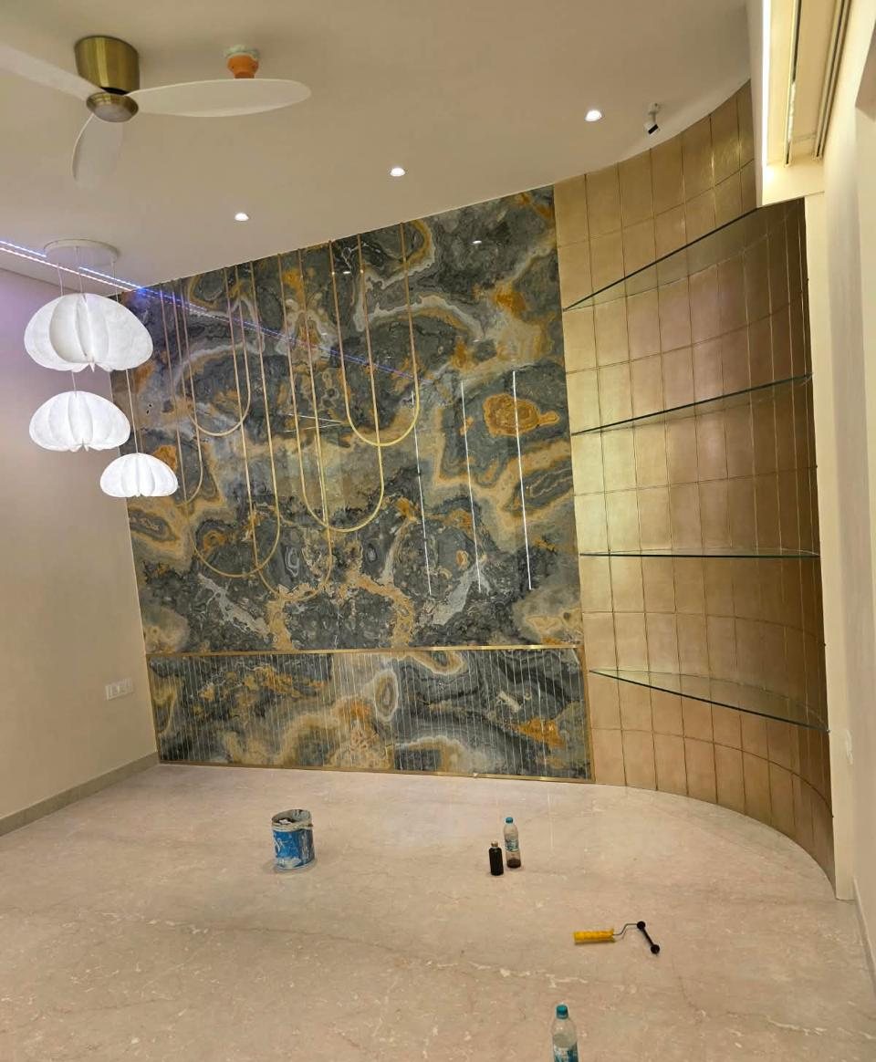 Onyx stone feature wall with brass inlays and curved glass shelving