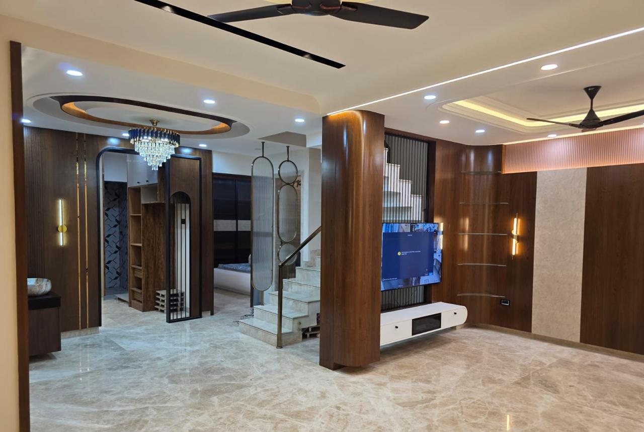Open-plan living area with walnut column and TV wall