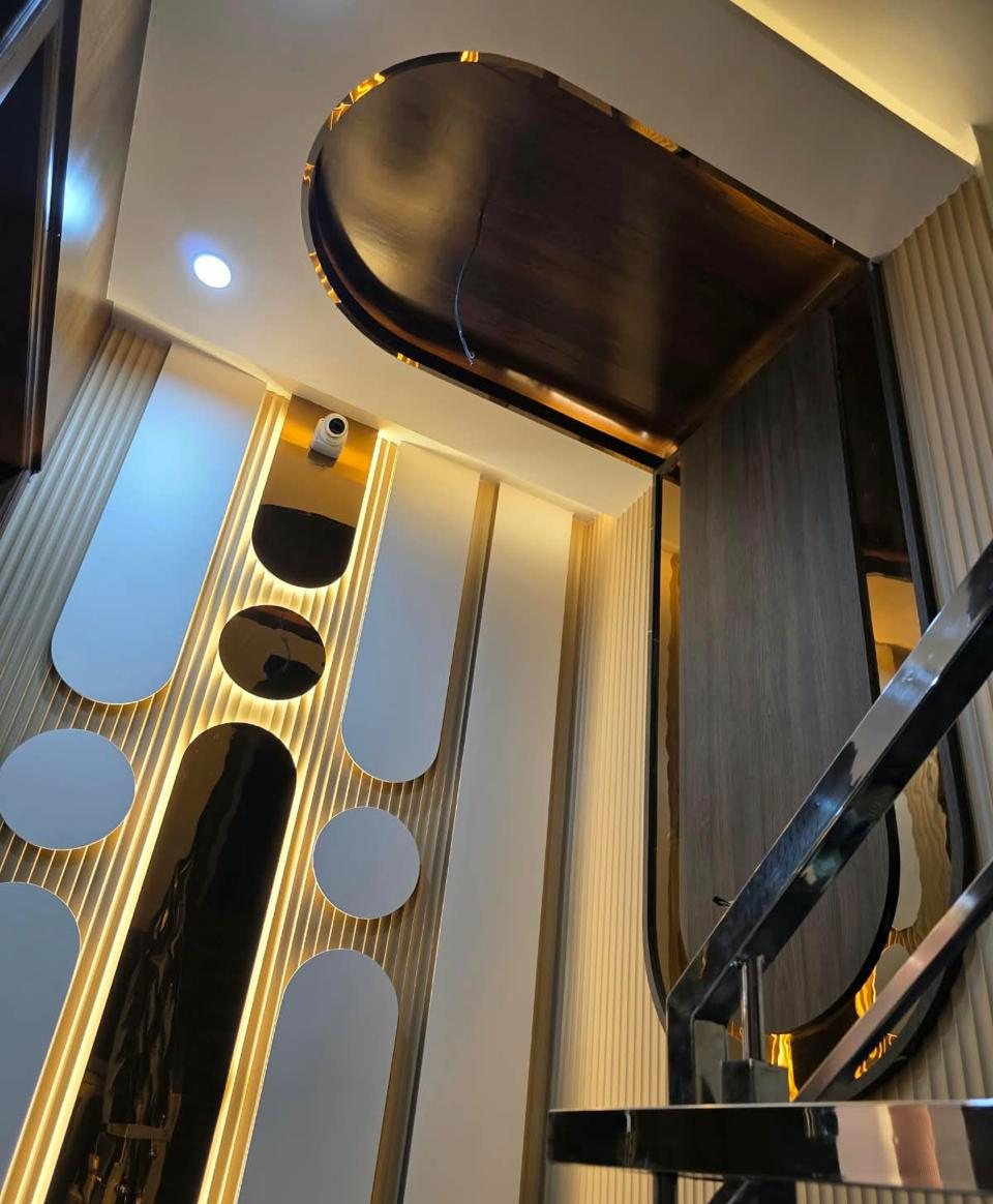 Staircase feature wall with fluted panels, mirror cut-outs and cove lighting